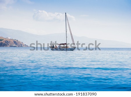 Small yacht in the blue sea off the coast with beautiful clouds