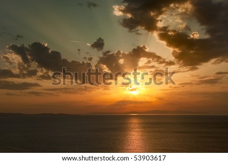 The picturesque colorful sunset into the sea with the sun through the clouds