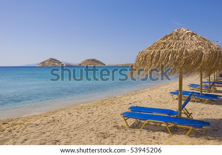 Sandy beach with umbrellas and sunbeds blue - found on any island in Greece and Europe