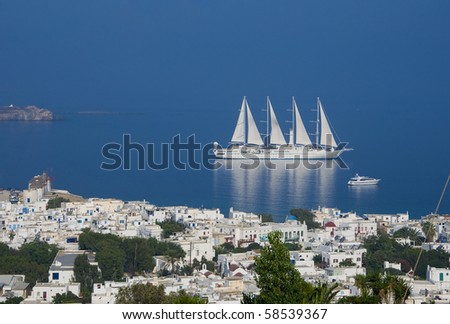 Top view of the town of Mykonos Island and a sailing ship in the blue sea ...