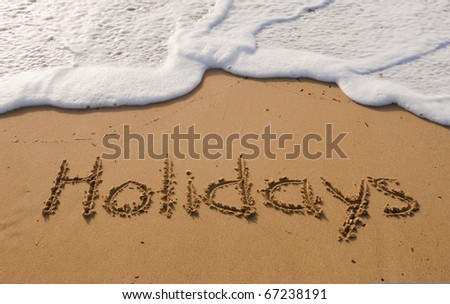 The inscription on the sand with a beautiful surf - holidays!