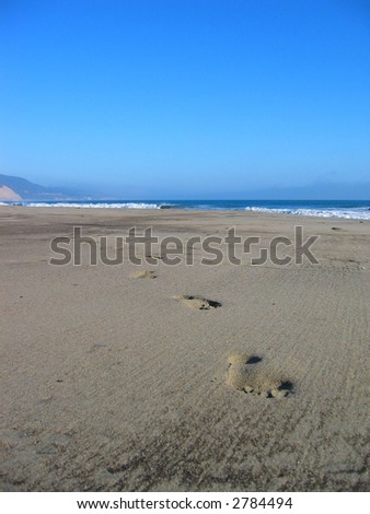 Foot steps on desert beach