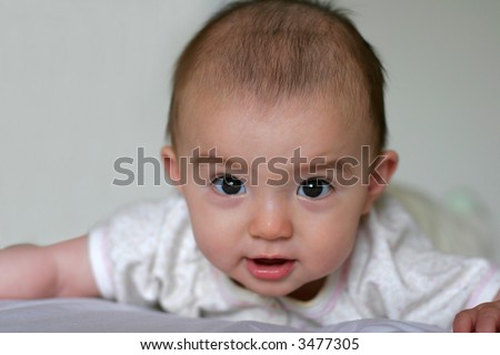Cute 6 Months old mixed baby girl trying to stand up