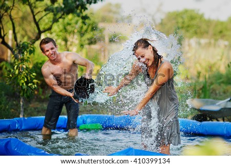 Young couple pours water and fun in summer. Fun summer holidays. Pouring cold water. Ice bucket challenge. Hardening treatment and a healthy lifestyle. Healthy man pours water from a bucket.