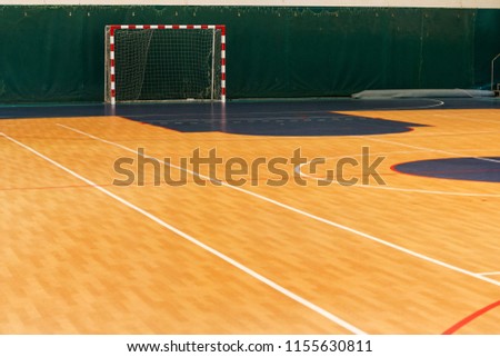 Gym for playing futsal, mini-football. Folded wooden parquet on the field of hall for mini-football. Futsal ball and bright line markings on the floor. Floor sports hall with bright lines of marking