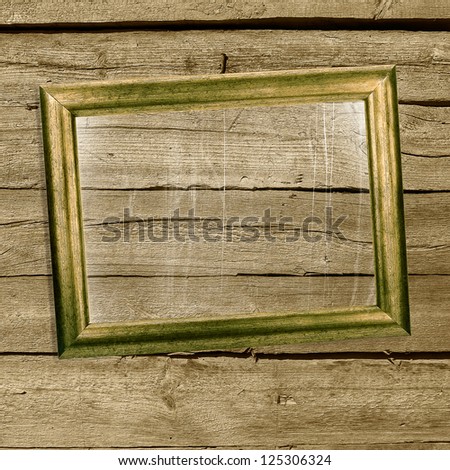 Old picture frames with scratched glass on grunge wooden wall