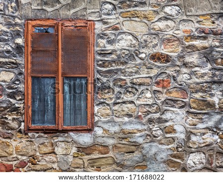 Old weathered cement wall exposing broken bricks background with old window
