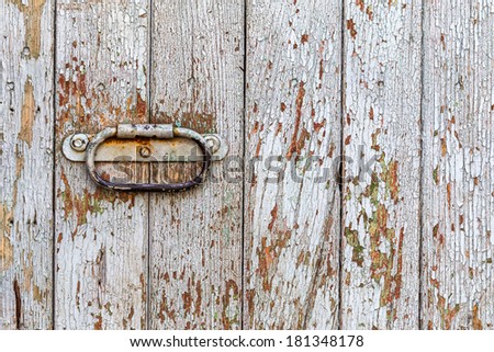 Grunge door painted with white paint with a rusty metal handle