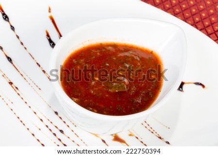 spicy tomato sauce in a gravy boat white