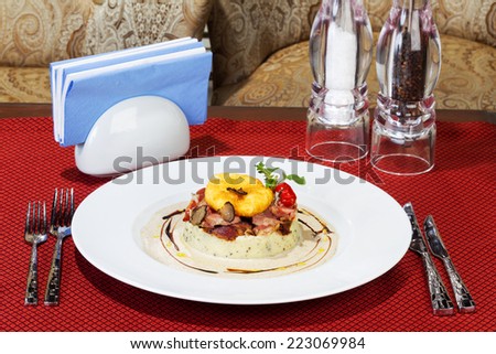 Mashed potatoes with bacon and sauce, selective focus. Table setting. Creative cuisine.