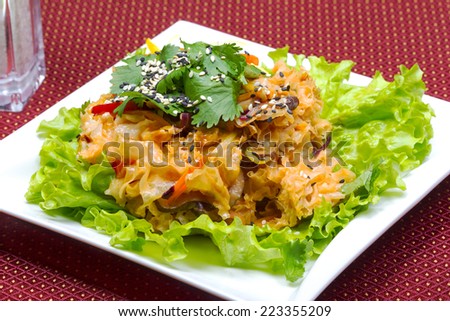 Coleslaw, green leaf lettuce and sesame seeds, selective focus. Table setting. Creative cuisine.