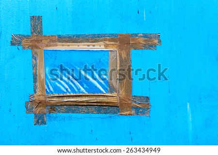 Vintage blue wall with cracks, scratches, frame is made from strips of old adhesive tape. Textured background for your concept or project. Great background or texture.