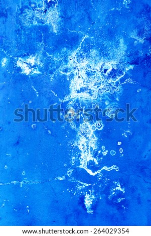 Creative beautiful blue background, blue spray paint on concrete with cracks and scratches. Landscape style. Grungy concrete surface. Great background or texture.