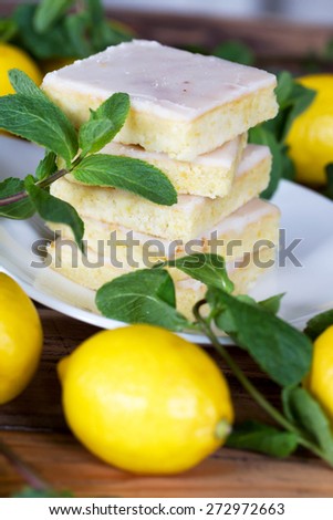 Authentic Shortcake Cake, a lot of fresh yellow lemons and mint. Morning atmospheric lighting, fashionable trendy spot soft focus. Preparation for design creative menu.