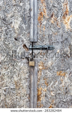 Grungy painted wooden door with a padlock. Background photo texture