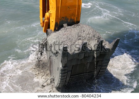 Excavator bucket of water from the soil of the seabed