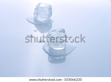 Two blue colored ice cubes melted in water