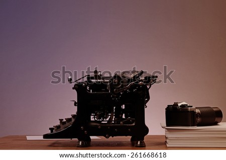 Old used typewriter with an old camera on an office table