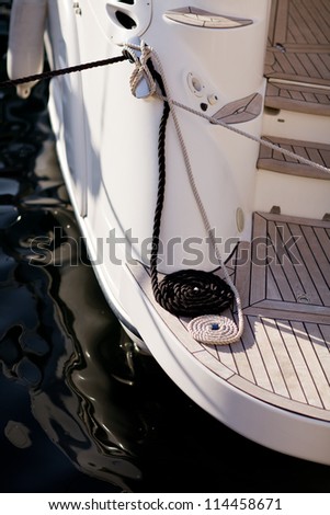 Steel anchor on boat or ship/ White mooring rope tied around steel anchor