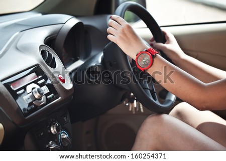 Close-up of a woman\'s hand on steering wheel in a modern car
