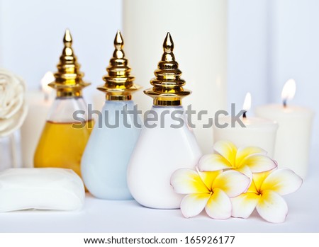 Three Plumeria flower with massage oil and balsam in bowl , towel and candle