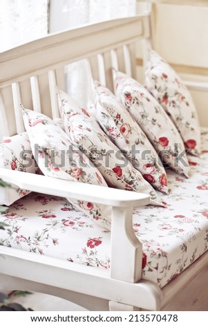 Floral pillow on white bench