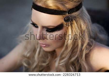 Fashion woman with long blond hair, make up and eye-patch