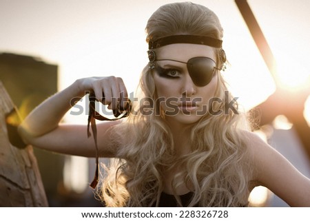 Fashion woman with long blond hair, make up and eye-patch