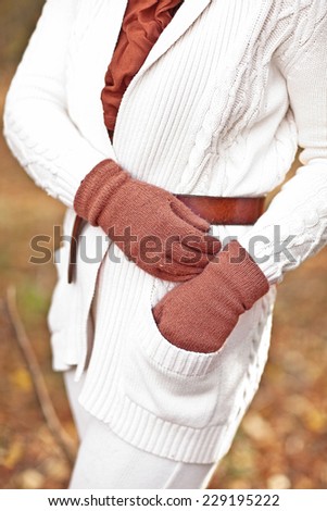 woman in a white sweater, gloves and scarf  in the fall autumn