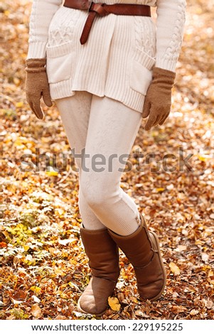 woman\'s legs in brown uggs in autumn forest