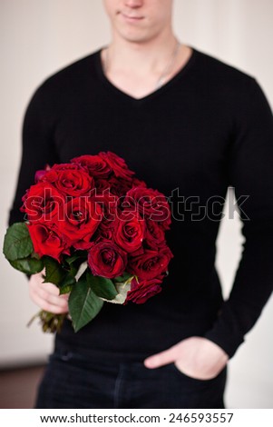 Happy romantic husband holding rose flower prepared to celebrate
