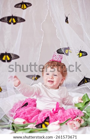 Beautiful lcute red-haired girl sits in white bed. Princess bed with butterfly.
