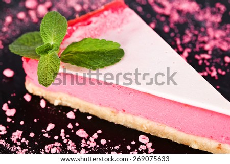 Raspberry tart, mousse cake, cheesecake with fresh mint on a black background