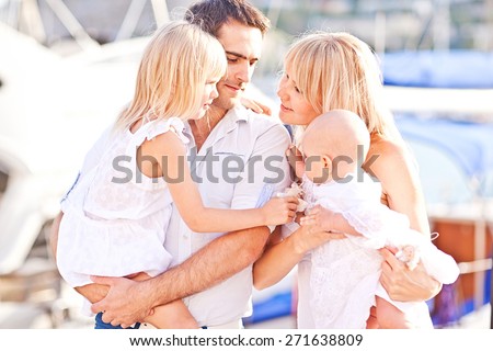 Happy family having fun walking on the mooring near yachts