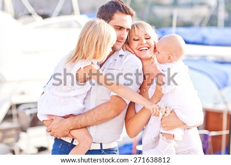 Happy family having fun walking on the mooring near yachts