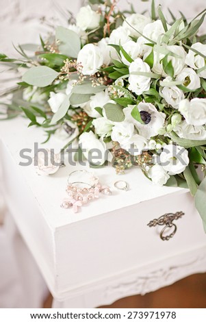 Beautiful white wedding bouquet on the white vintage bedside table