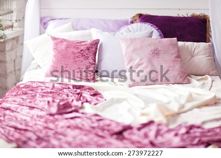 White cozy bed with vintage pillow and flowers