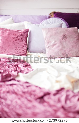 White cozy bed with vintage pillow and flowers