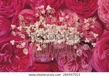 Wedding accessories to hairstyle on tenderness rose background. Hand made hair-pin.