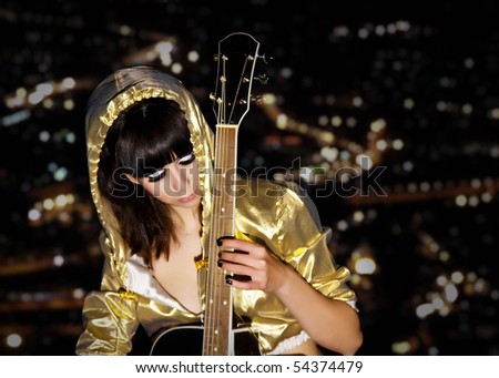 young girl with a guitar on a roof of a high-rise building