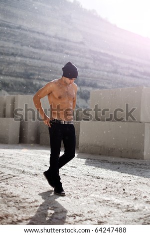 muscular man in jeans under the rain