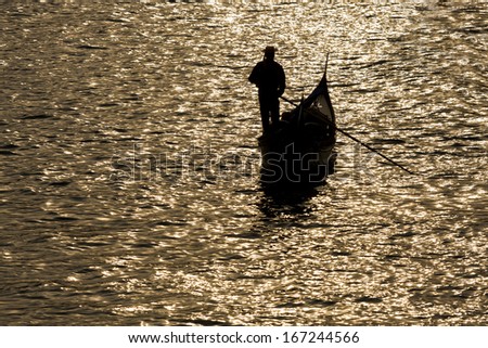 Gondola silhouette on venetian canal at evening, Venice, Italy