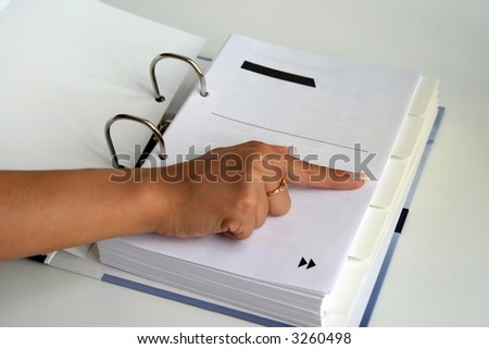 The index finger shows on a bookmark in huge quantity of pages collected in one greater thick writing folder