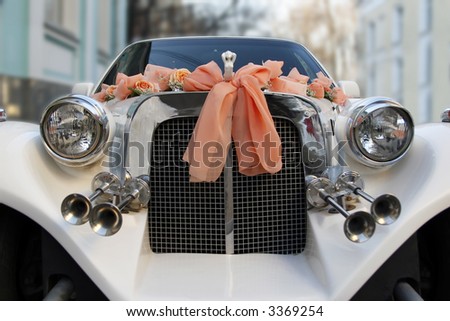The wedding limousine decorated by tapes and colors expects the groom and the bride for walk