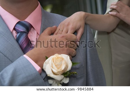 Enamoured newly-married couple passionately and gently keep their hands
