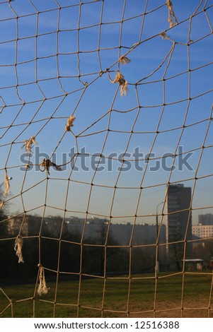 Sight at an apartment house through a grid of a football gate on surburb of city