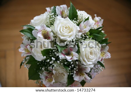 Wedding bouquet of the bride from white roses on a background of pink gentle flowers