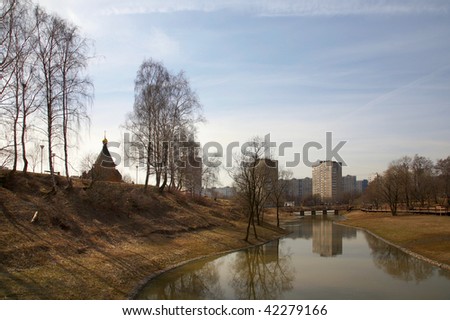 The river and church on the brink of a modern city in the spring