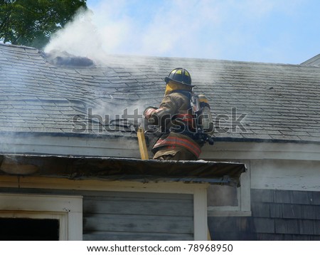 fire fighter on roof of house fire