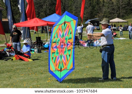 KORTRIGHT CENTER Ã¢Â?Â? MAY 06: Man with colorful kite at  Four Winds Spring Kite Festival in May 06, 2012 in Kortright Center in Ontario, Canada.